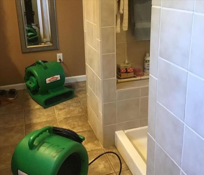Bathroom with standing walk in shower and green fans drying the area